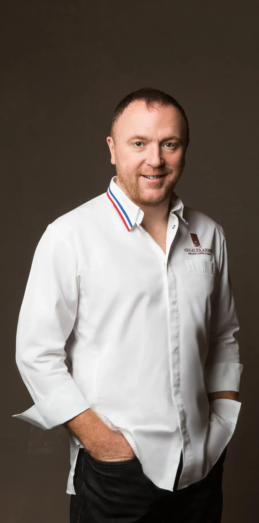 Arnaud Larher, Meilleur Ouvrier de France Pâtissier, in weißer Kochjacke mit Trikolore-Kragen, Foto von Fauchon