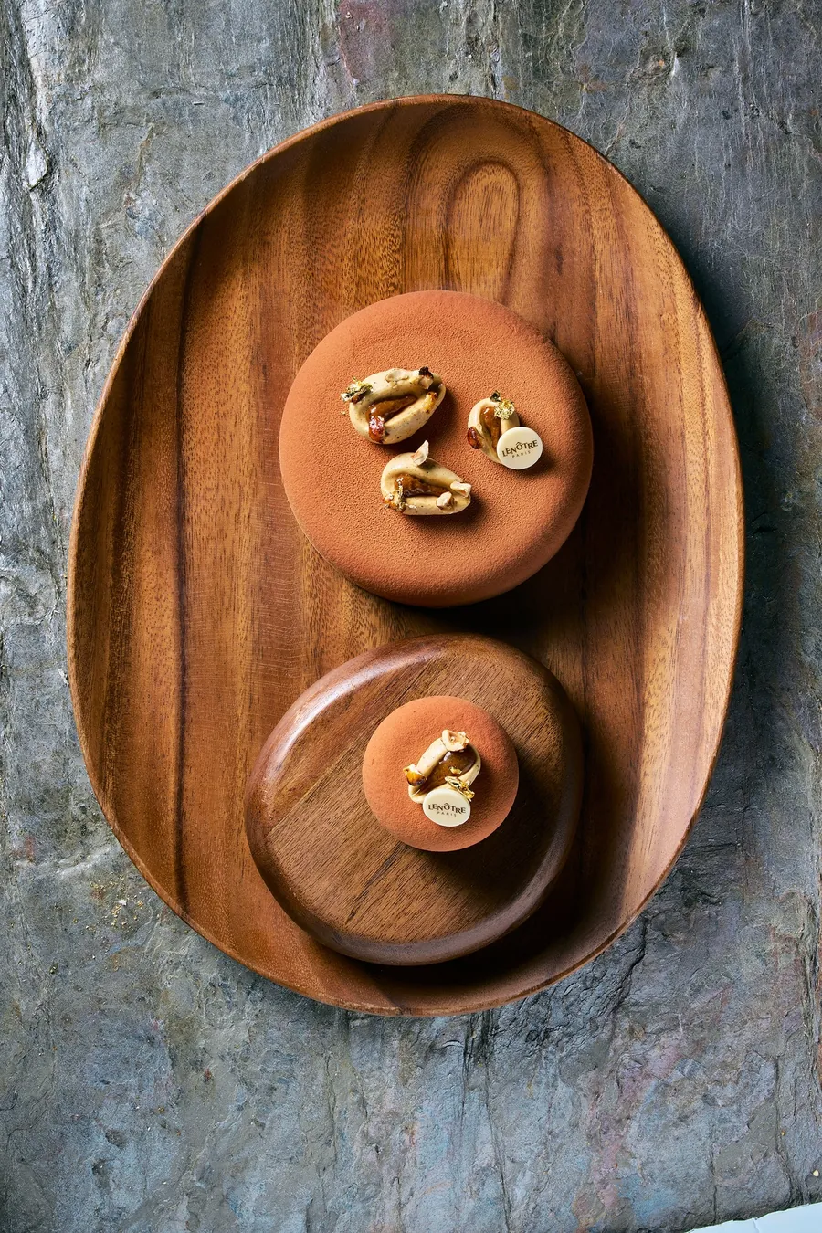 Lenôtre Velours noisette in groß und als Einzelstück auf einem Holztablett, Foto von Lenôtre